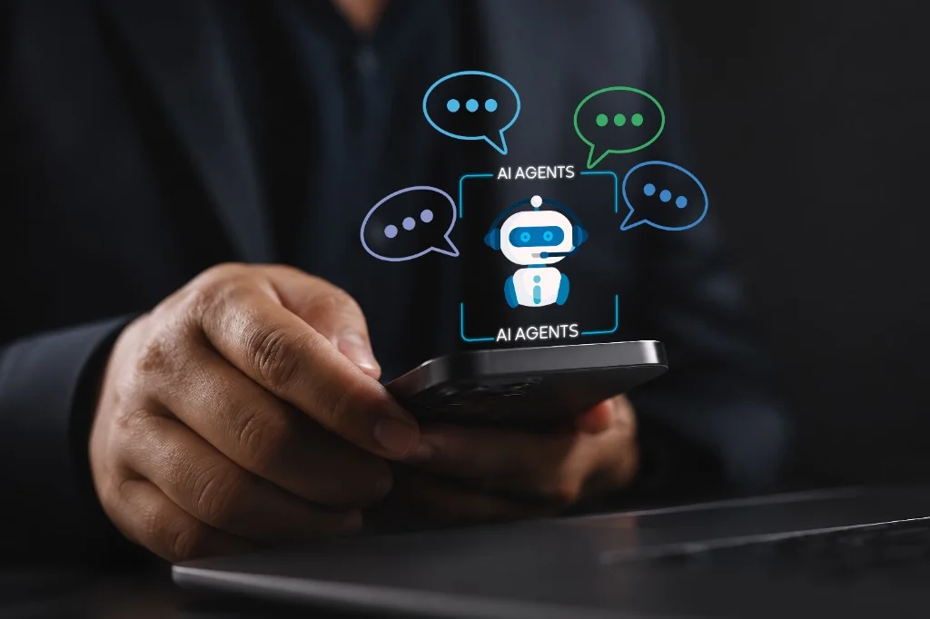 Person holding a smartphone with an AI chat agent robot and glowing chat-bubble icons floating above the screen
